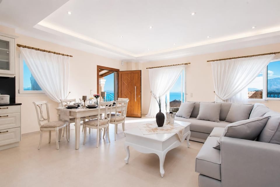 Open-plan living room with sofas, dining area, kitchen, A/C, WiFi internet, satellite TV, DVD player, and terrace access with sea views