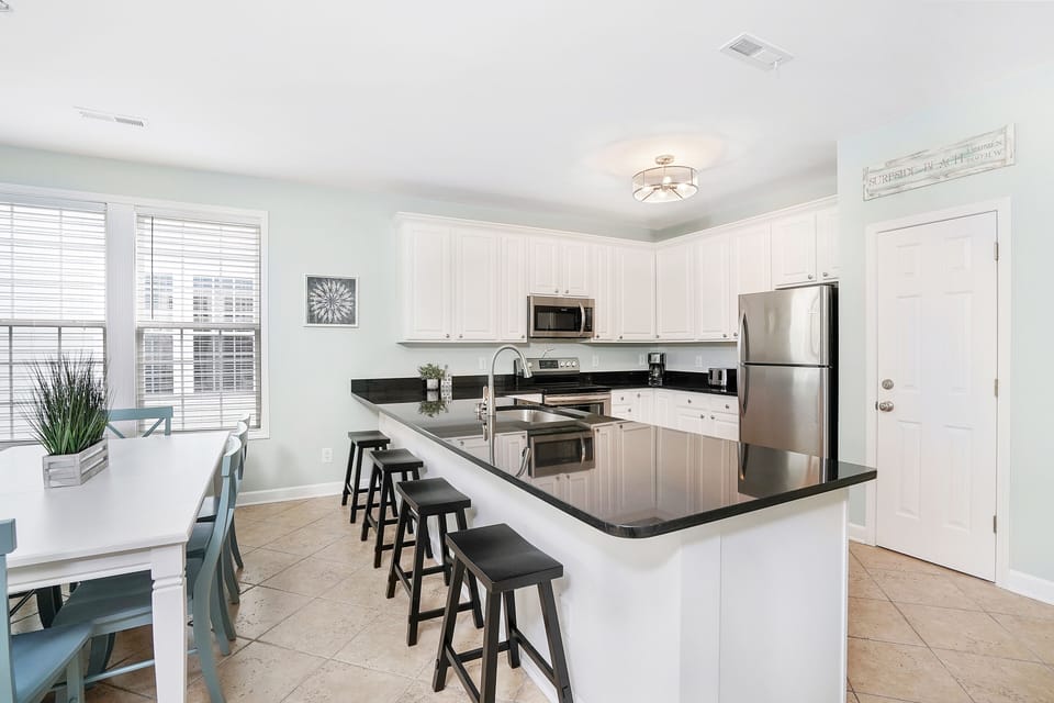 Your spacious kitchen welcomes you with gleaming granite counters, stainless appliances, and a breakfast bar perfect for morning coffee or casual meals together.