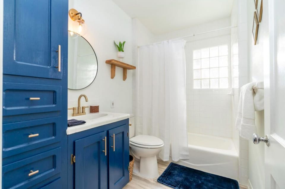 A nautical navy blue and brass is found in the bathroom.