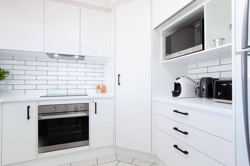 Kitchen with Nespesso coffee pod machine and other appliances.