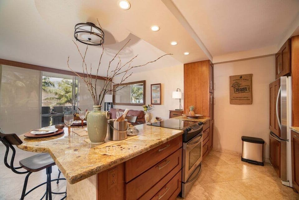A spacious kitchen with extended granite countertops and custom wood cabinetry offers ample room for meal prep and gathering.