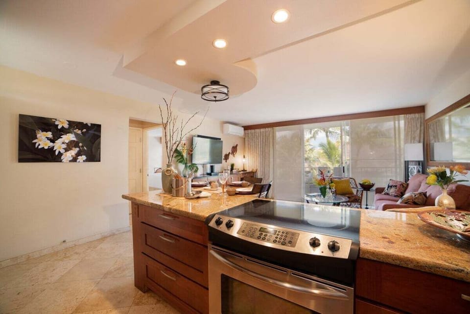 A well-appointed kitchen with stainless steel appliances and polished granite counters creates a bright, functional cooking space.