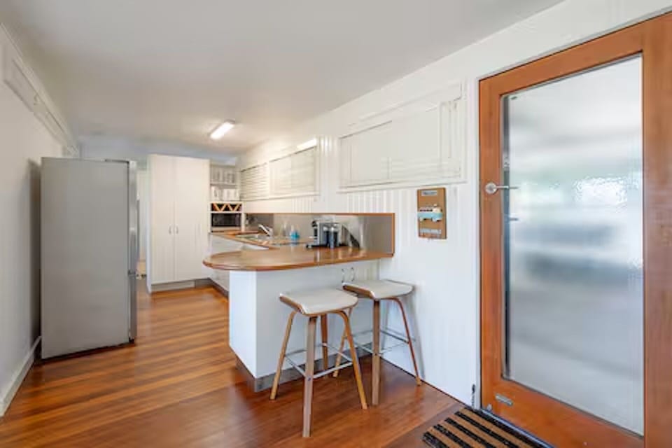 Full kitchen with oven, stove, fridge, microwave, pots, pans, and crockery.