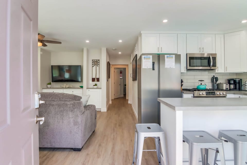 Entryway view to living and kitchen. Sliding glass door opens to patio. 