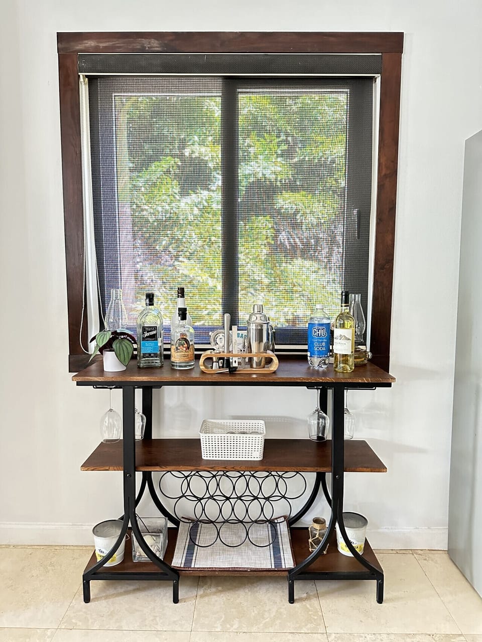 The bar features a sleek wine rack, along with ample space for beverages and wine glasses, creating the perfect spot for serving and storing drinks.