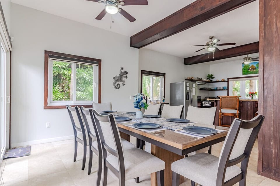 With a spacious layout, comfortable seating including a couch and two chairs with ottomans, and a large-screen TV, the living room is designed for both comfort and leisure.