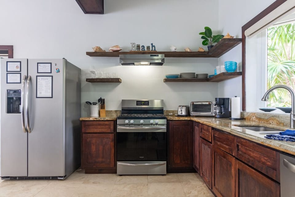 This inviting kitchen features open upper shelves, plenty of dinnerware for 12 guests, and a perfect blend of style and practicality for memorable gatherings and culinary creations.
