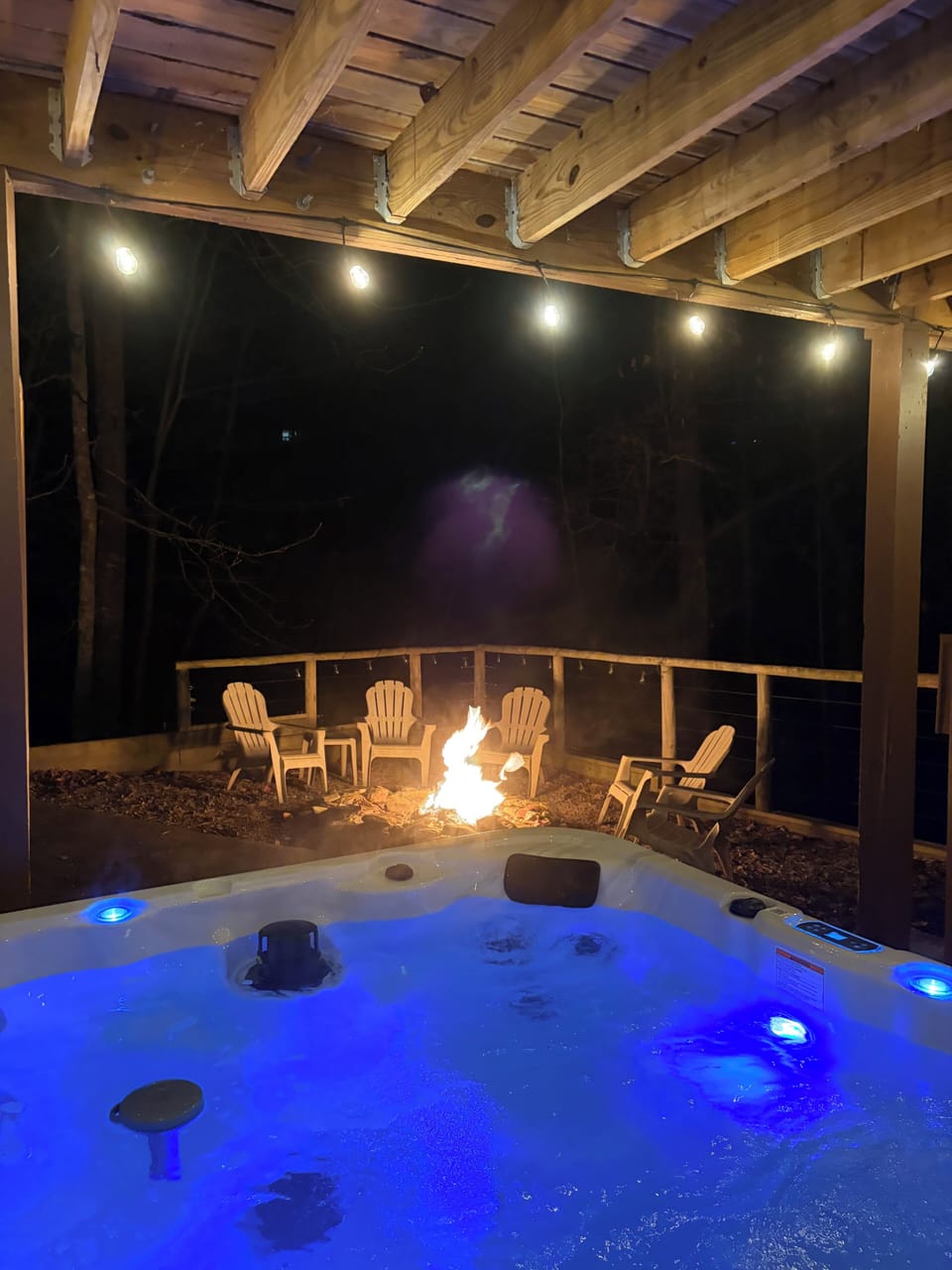 Covered hot tub with a view of the fire pit