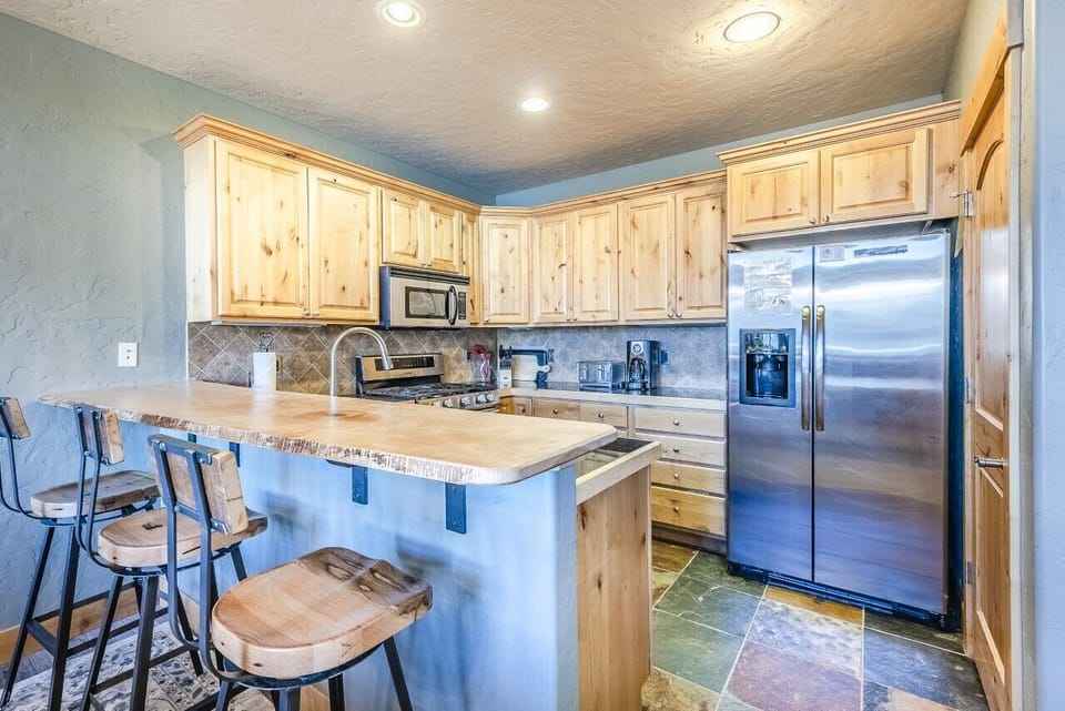 Kitchen - Kitchen with bar/peninsula. Stainless steel appliances. Bar offers additional seating for 3.