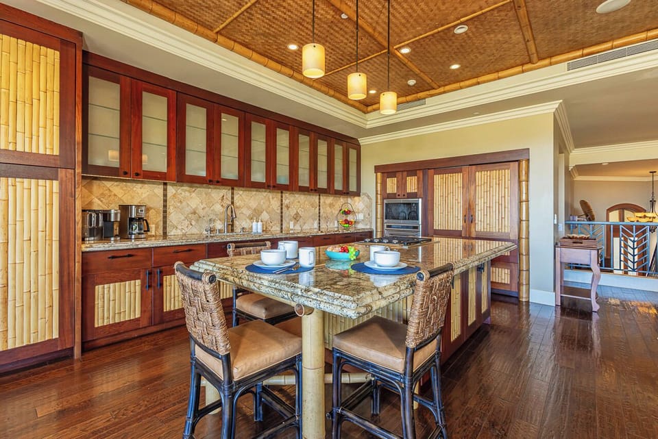 Your gourmet kitchen combines island charm with modern convenience, featuring rich wood cabinetry, bamboo accents, and a spacious granite island where you can gather for meals or coffee.