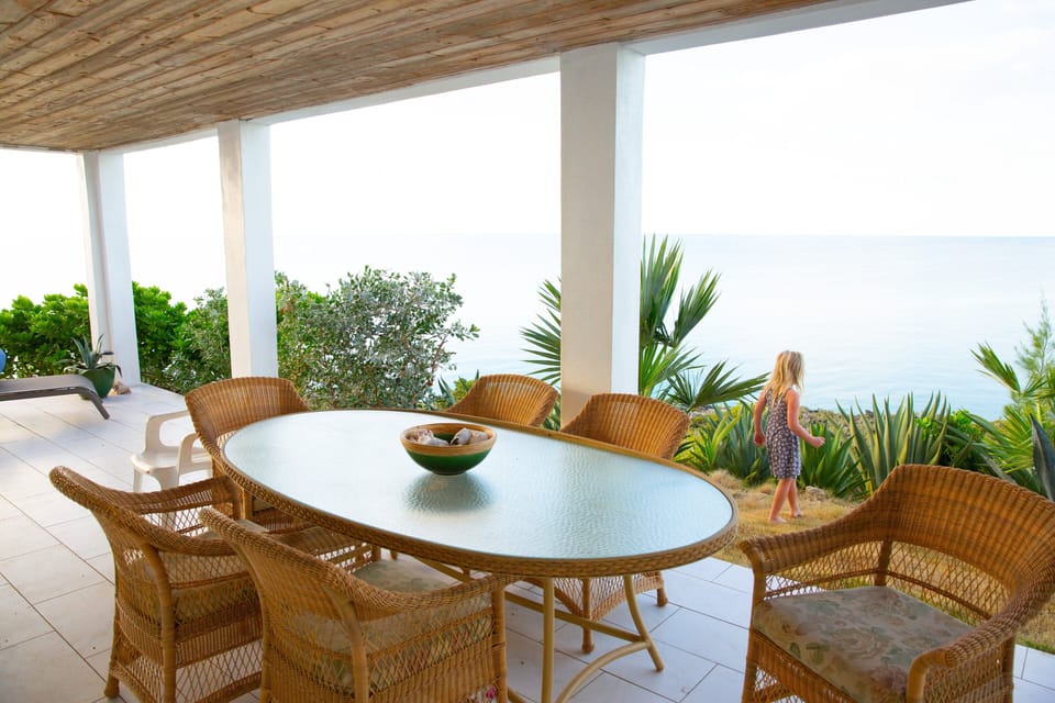 Lower level veranda with outdoor dining and lounge chairs.