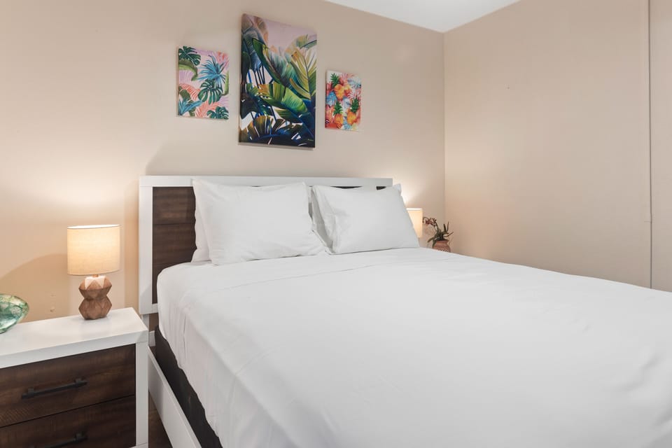 Guest bedroom with beautiful artwork and comfortable queen size bed.