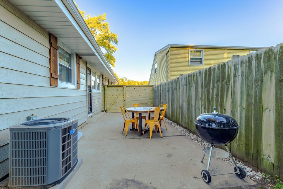 Fully fenced in backyard. Bag toss, fire pit, outdoor table with seating and charcoal grill.