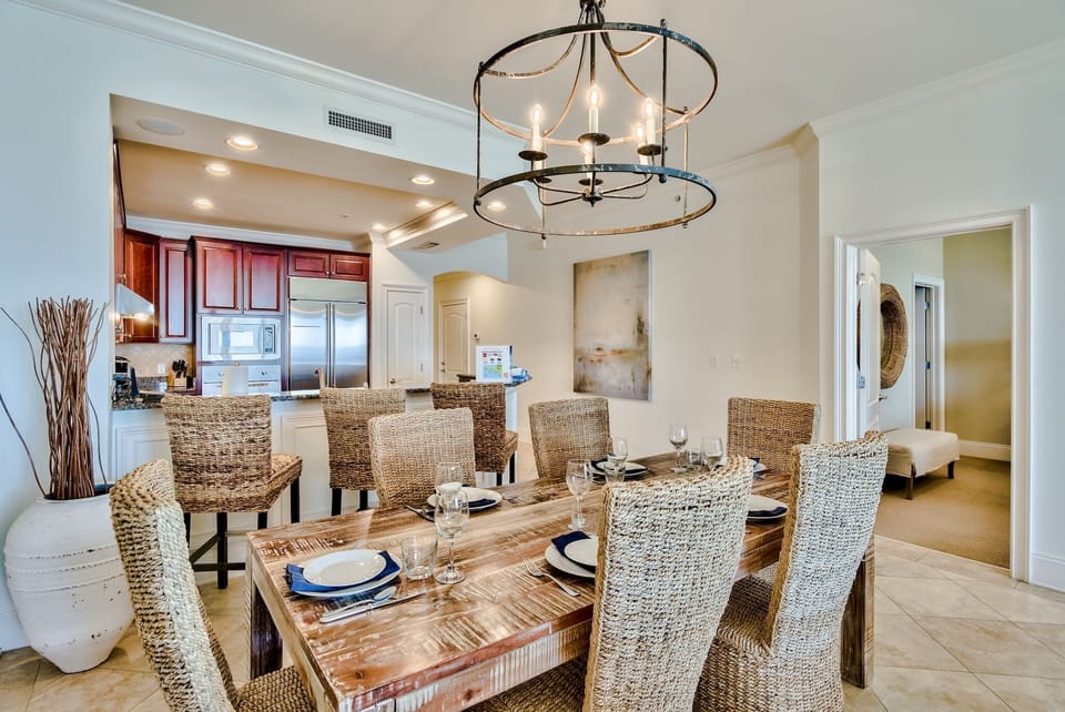 Dining area of A402 - Eight chairs at dining table (two are out of the picture) and three barstools at the nearby kitchen granite counter top.