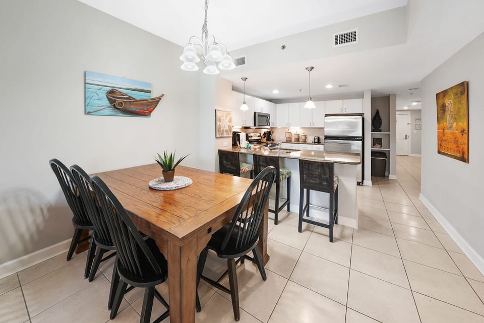 Your open-concept dining and kitchen space features a warm wooden table and modern appliances, perfect for sharing meals together.