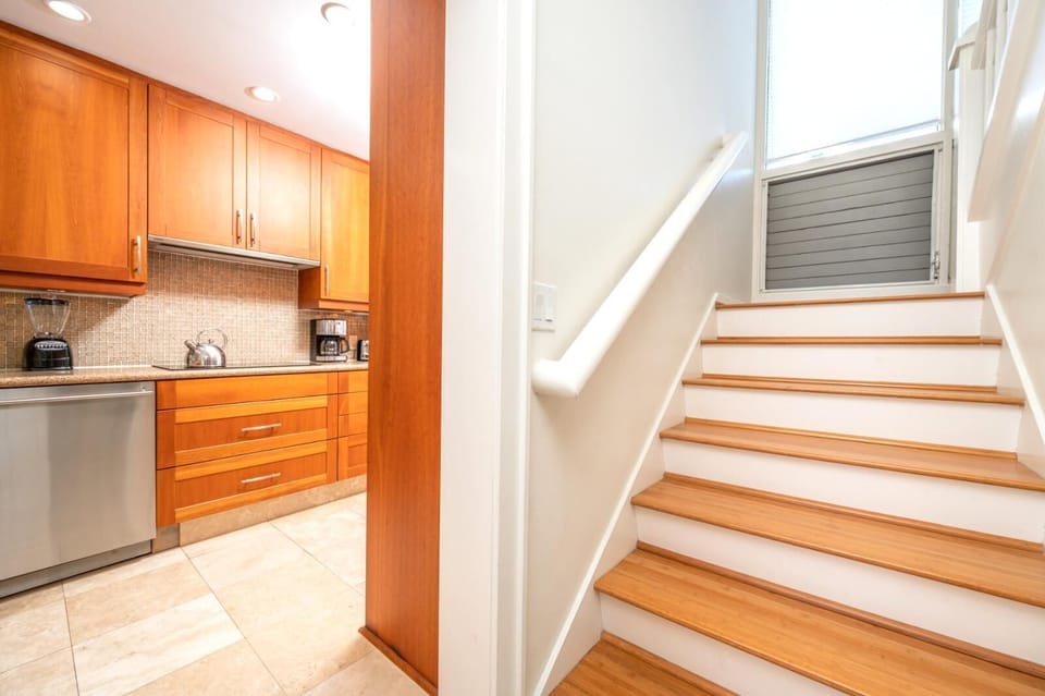 A soft and welcoming staircase with matching wood tones connects the lower level with tranquil flow upstairs    