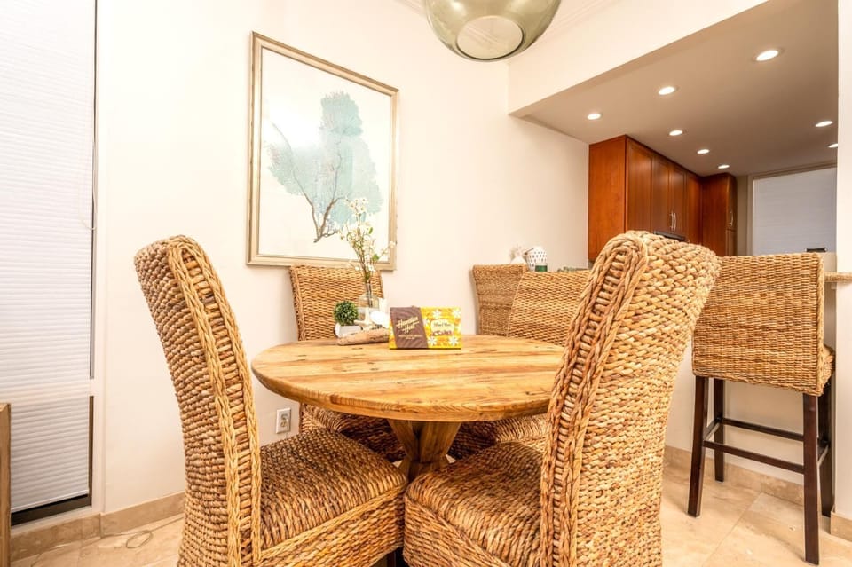 Gather around a handwoven rattan dining set nestled beneath soft pendant lighting, just steps from the ocean breeze    
