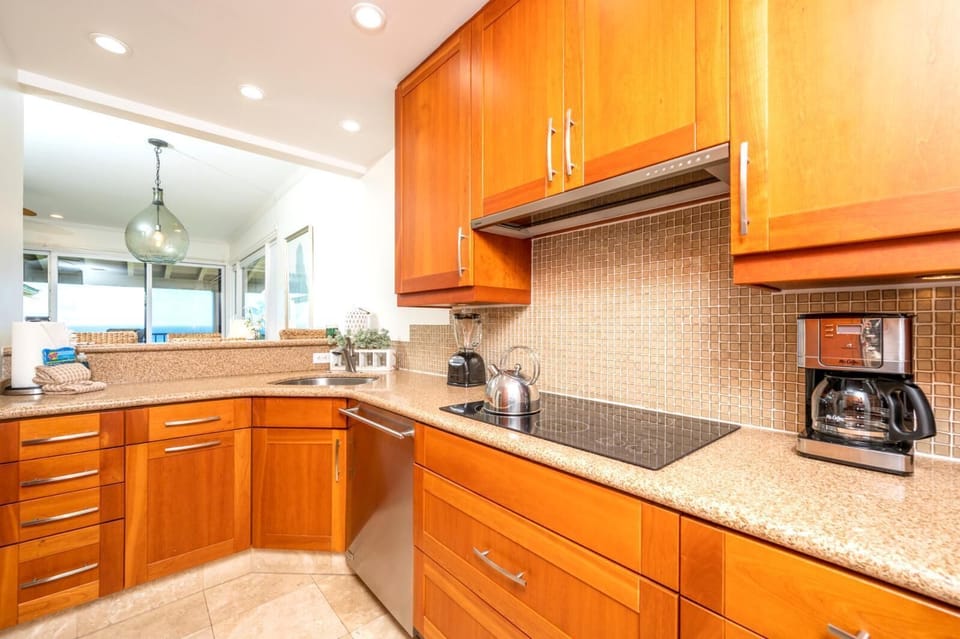 Double built-in ovens make hosting easy, and the hallway leads to a chic powder room for added convenience    