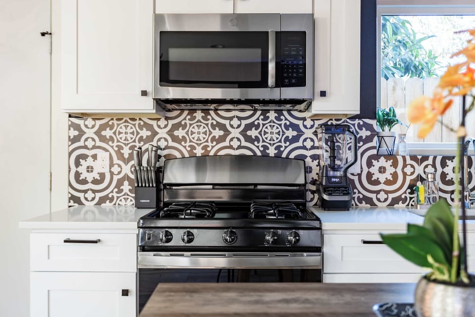 Fully Equipped Kitchen With Stylish Patterned Backsplash And Modern Appliances