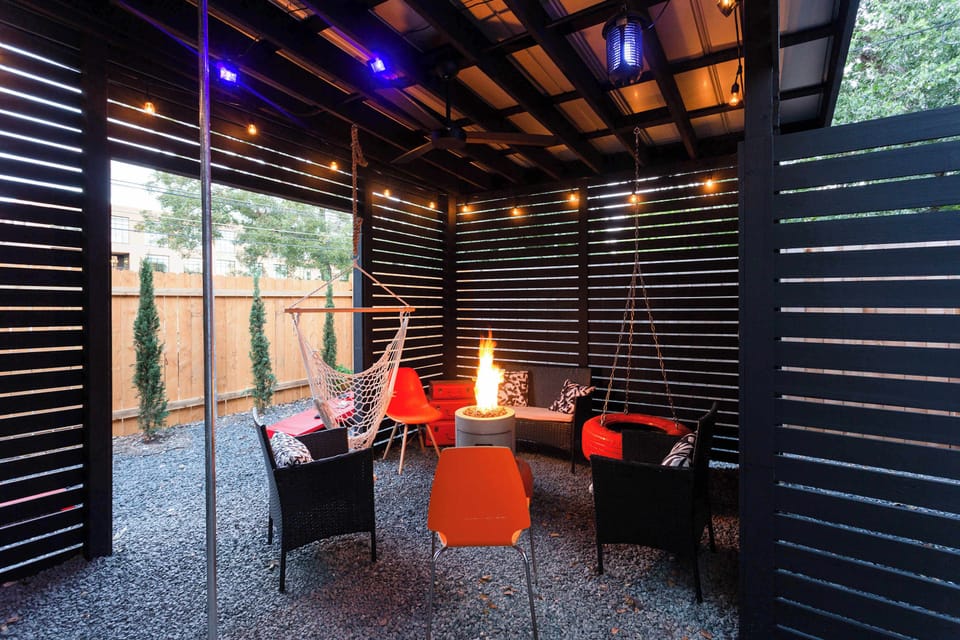 Covered Patio With Fire Pit And Hanging Chairs For Relaxation