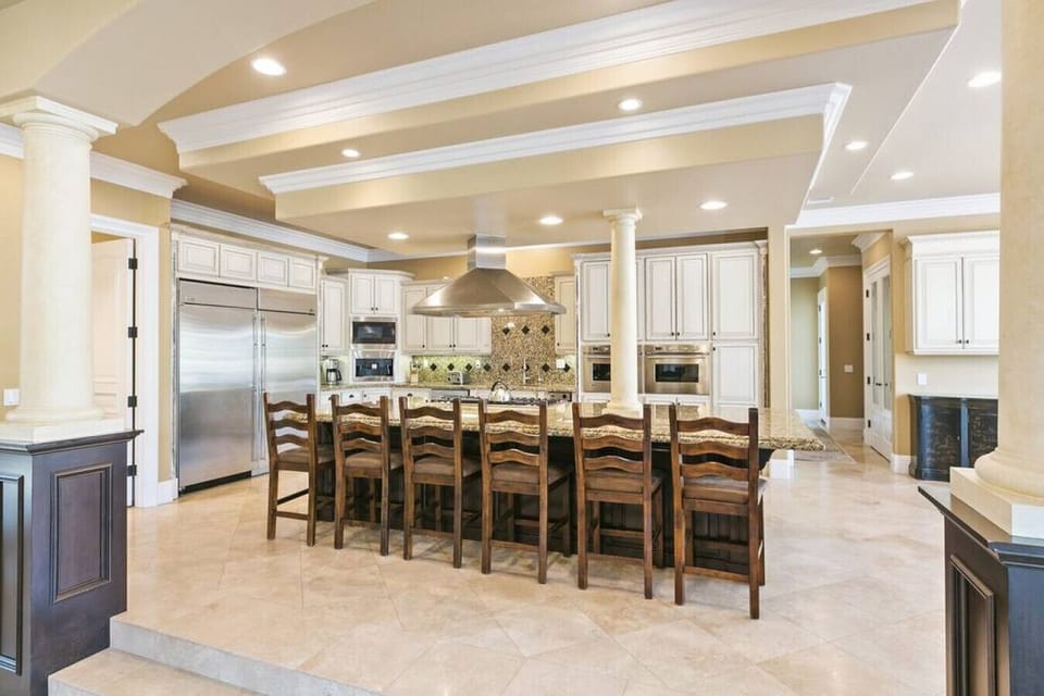 [Kitchen] Fully equipped for gourmet cooking with gas stove, double ovens, large side by side fridge, breakfast counter seating, and more