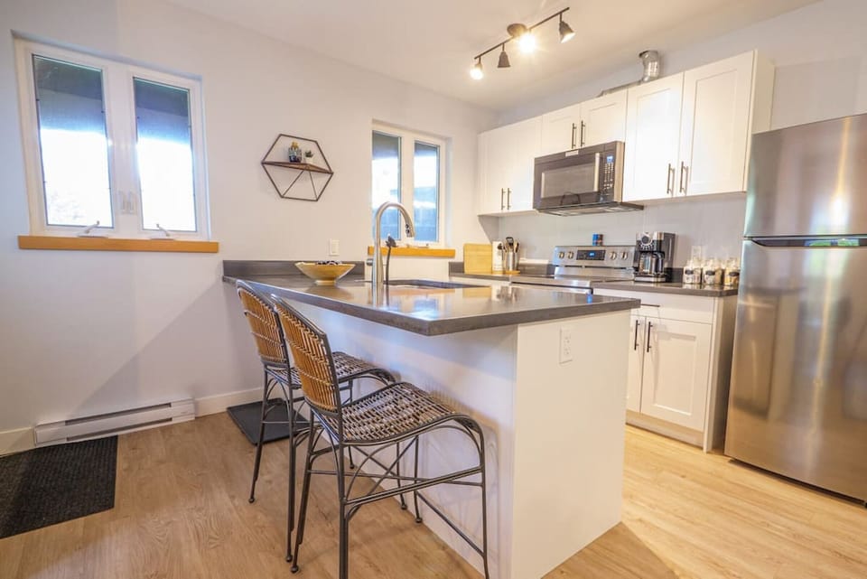 Modern Kitchen with Stainless Steel Appliances, and Two Bar Stools