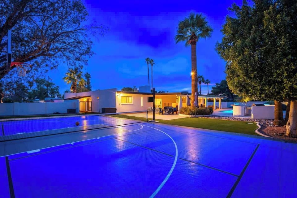Modern desert retreat featuring a private basketball court, palm-studded grounds, and covered patio—perfect for active escapes and warm-weather entertaining under the stars.