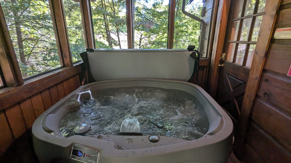 Hot tub on back deck across from BBQ area, screened in and cozy!