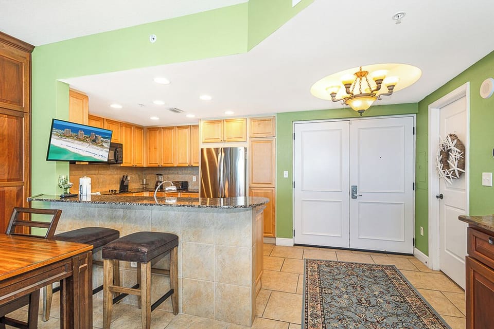 Your spacious kitchen welcomes you with warm wood cabinets, granite counters, and stainless appliances—perfect for cooking memorable meals during your stay.