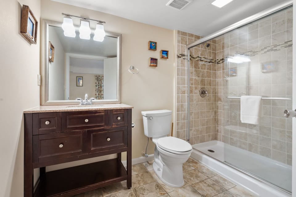 Bathroom with a walk-in shower, vanity and lit mirror at Sea Castle 3F in Crescent Beach, North Myrtle Beach