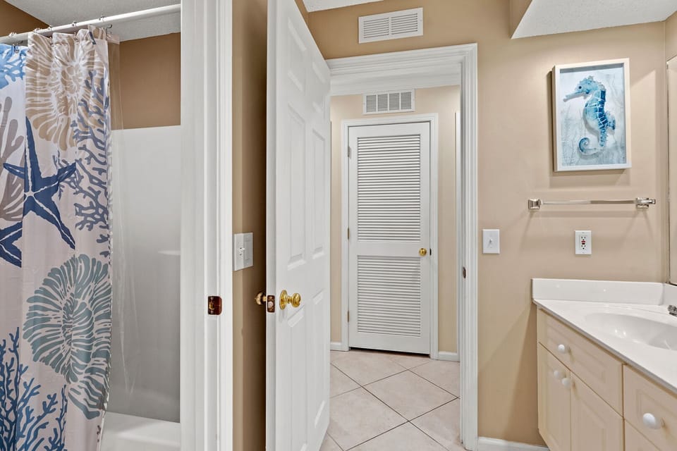 Bathroom with a sea-life curtain, seahorse art and vanity at Shorehaven J1, a Tilghman Beach rental