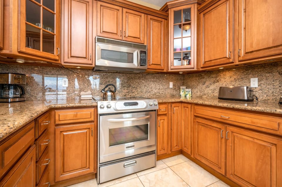 This warm, wood-accented kitchen offers granite countertops, stainless appliances, and seamless flow into the dining area    