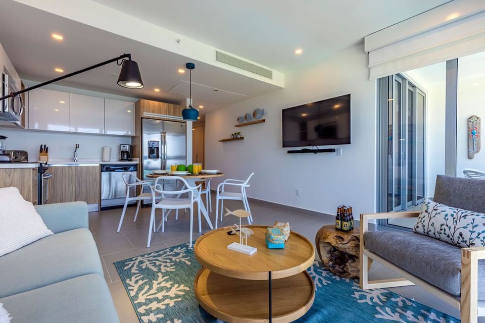 Your bright, open-concept space seamlessly blends living, dining, and kitchen areas with coastal-chic decor, modern furnishings, and easy balcony access for relaxing after beach days.