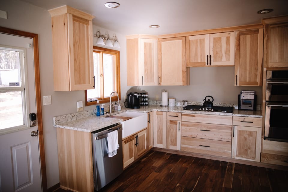 Kitchen has new stainless appliances, farm sink, granite, and gas stovetop.