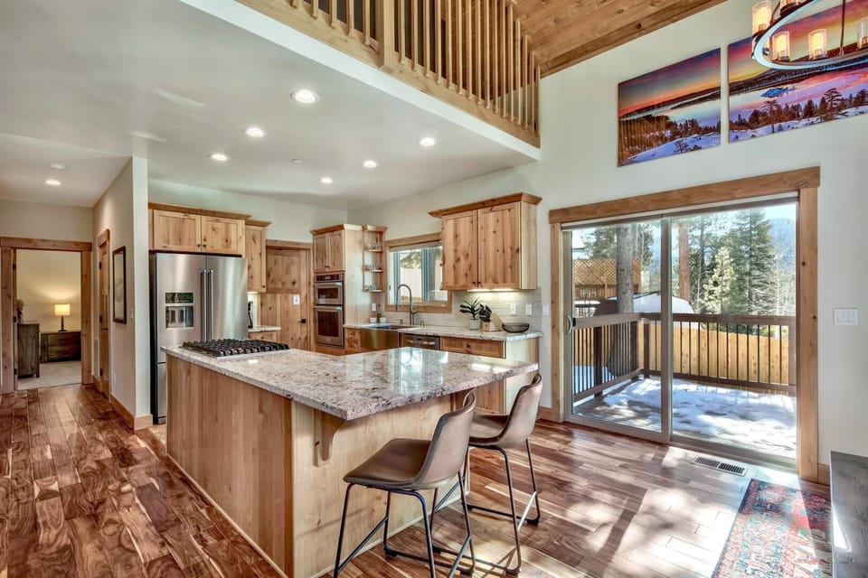 Your spacious chef's kitchen opens to mountain views, featuring granite countertops and a breakfast bar perfect for morning coffee.