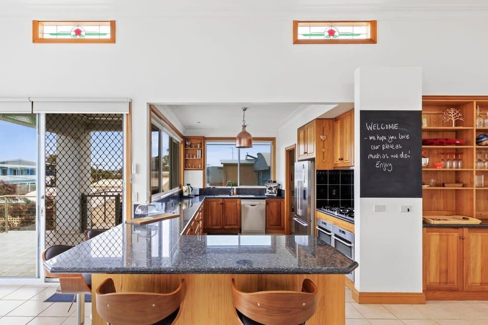 The stunning kitchen boasts timber cabinetry, dual ovens, gas cooktop, butler’s pantry and a huge stone bench incorporating casual dining and bar stools