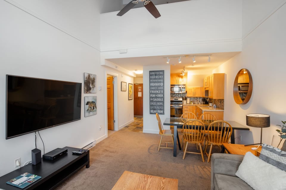 Living Room - Cozy fireplace, SmartTV, large vaulted ceilings, comfortable sofa and lounge chair.