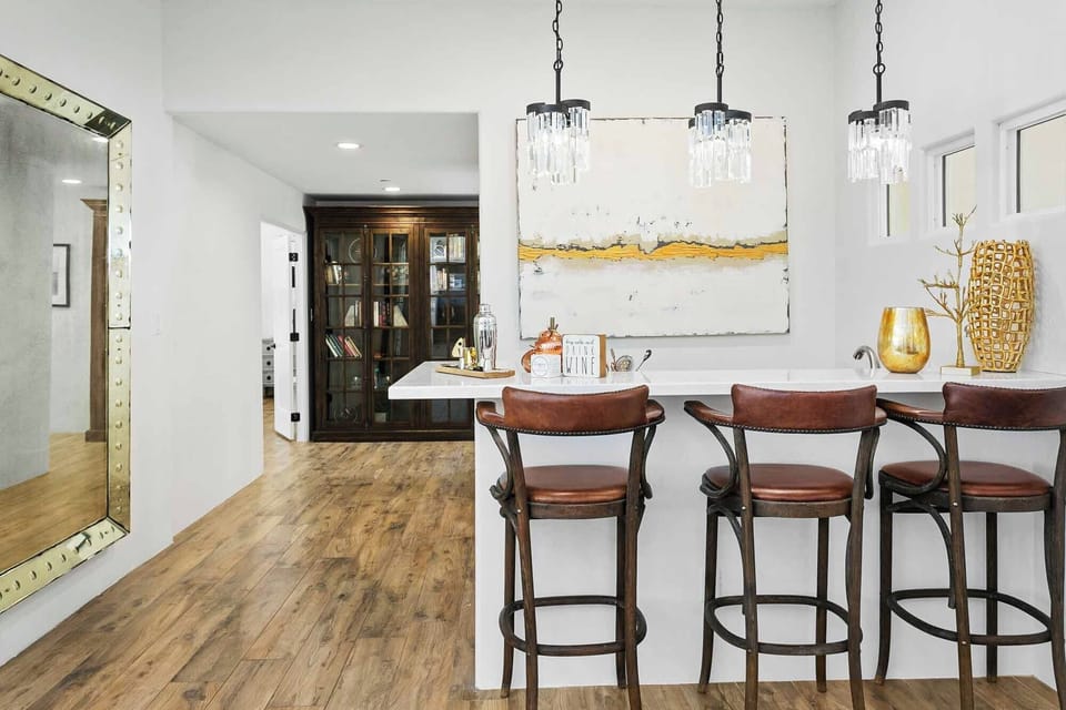 Bar with 3 barstools, sink, and beverage fridge