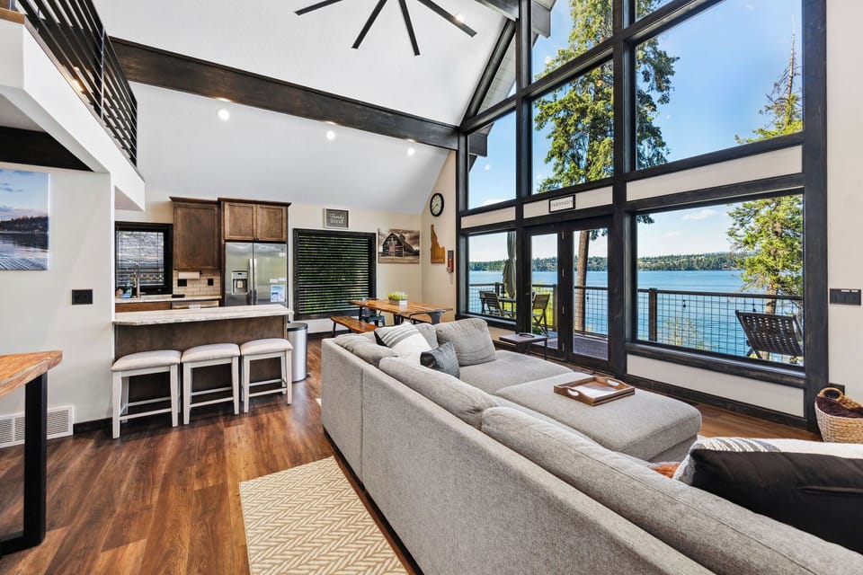 Sink into the plush sectional and let your gaze drift through soaring floor-to-ceiling windows to the sparkling lake beyond—your perfect spot to unwind after a day of exploring.