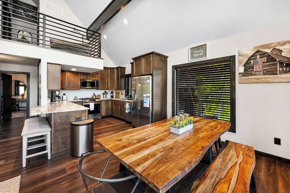 Gather around this stunning wood dining table where your family meals become cherished memories. The open kitchen invites you to cook and connect in a bright, welcoming space.
