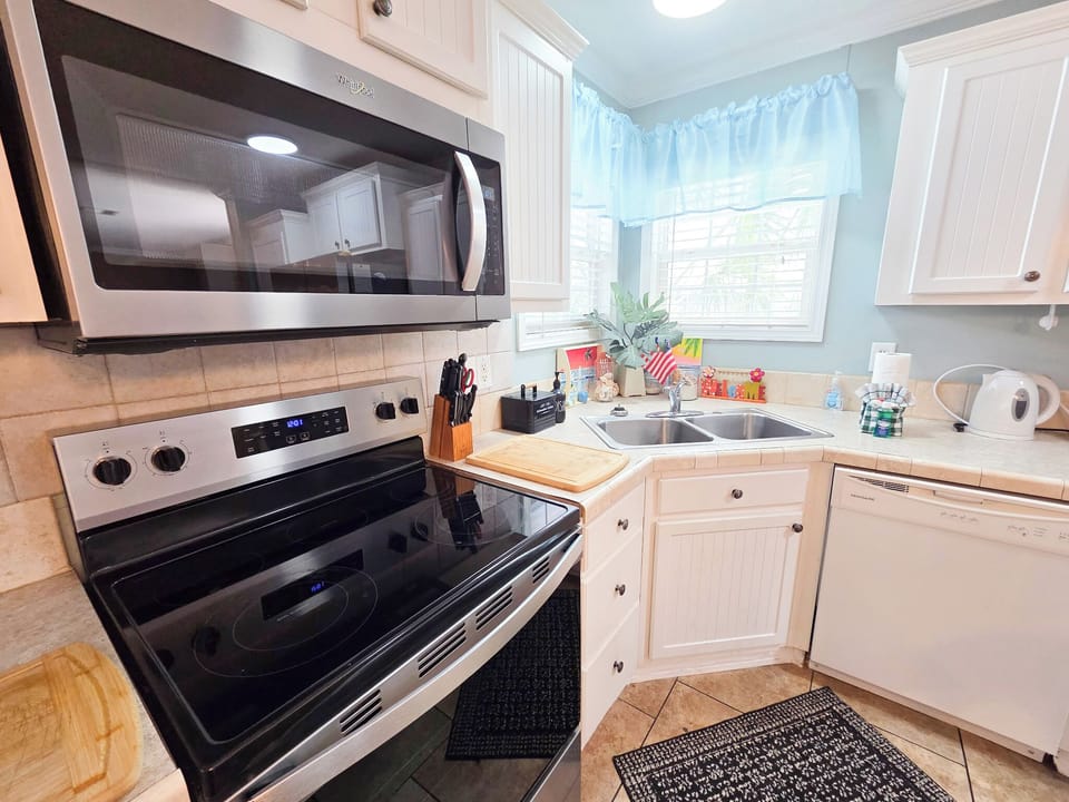 Full kitchen with glass top stove and oven, dishwasher and more.