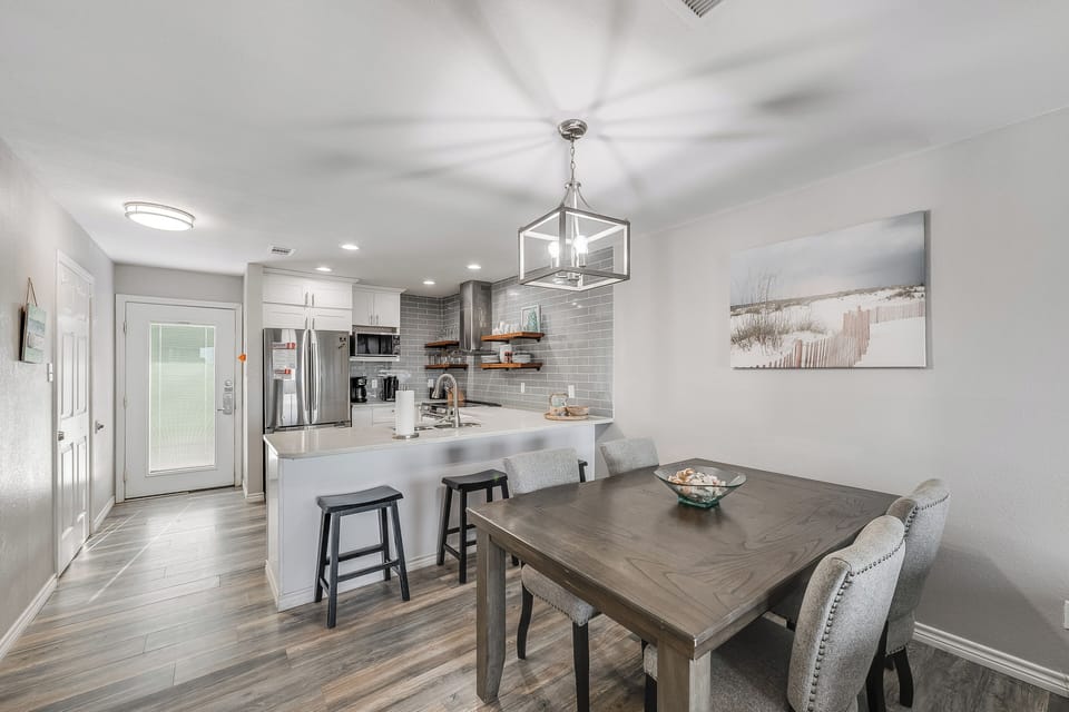 Your modern kitchen flows seamlessly into the dining space, where you'll gather around the stylish table under elegant pendant lighting.
