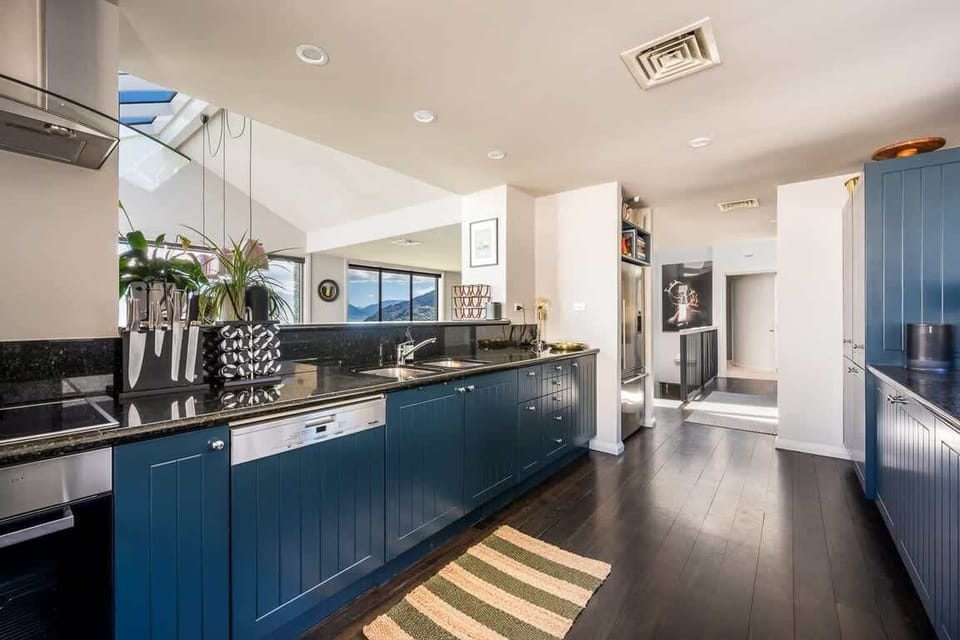 Modern Entertainer’s Kitchen Prepare meals with ease in the fully equipped kitchen, designed for style and functionality, with seamless flow to the outdoor patio.