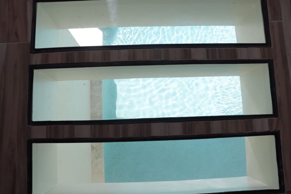 Unique floor glass overlooks the pool below 