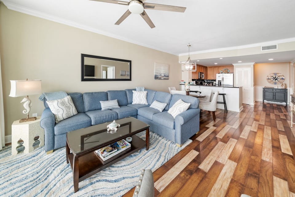 Unwind on your spacious sectional sofa with ocean-themed décor flowing seamlessly into the open kitchen—perfect for memorable gatherings.