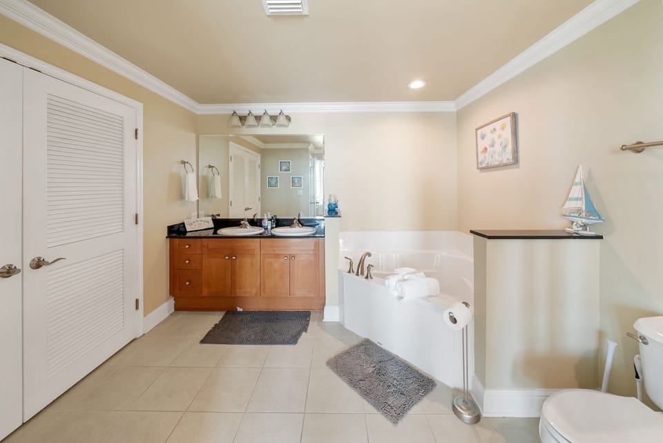 Unwind in your spacious master bathroom featuring dual vanities, soaking tub, and coastal touches for pure relaxation.