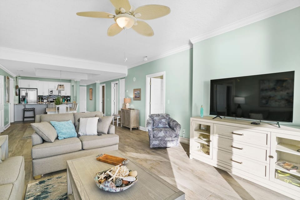 Sink into your spacious living room with soft coastal colors and comfortable seating, perfect for relaxing after beach days.