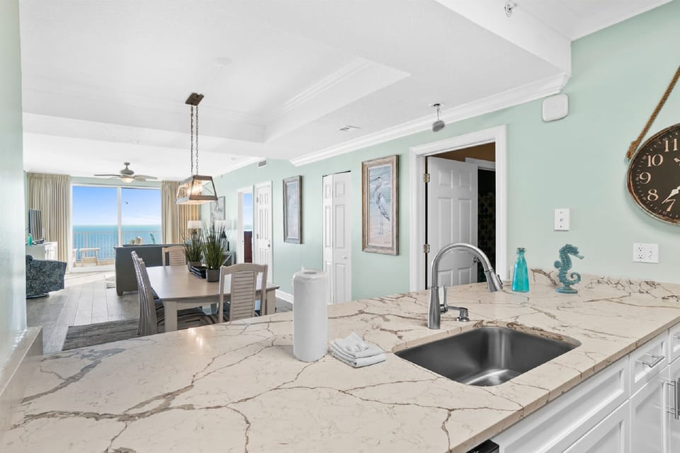 Your gourmet kitchen flows into a bright dining area with stunning ocean views through floor-to-ceiling windows.