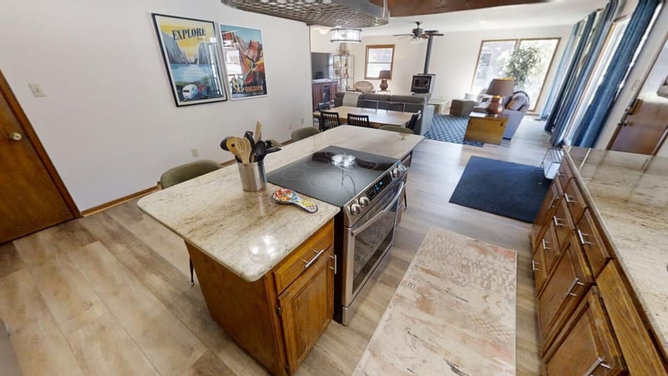 Step into your spacious open-concept living area, where the kitchen flows seamlessly into the dining and lounge spaces—perfect for gathering, cooking, and relaxing together under vaulted ceilings.