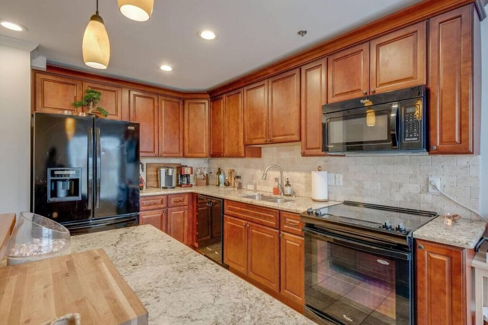 Kitchen is stocked with cookware, utensils, & glassware.